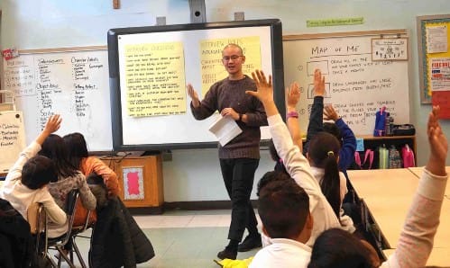 Teaching artist Karl Orozco preparing his students for their interviews with a community guest who came to the United States as an immigrant.